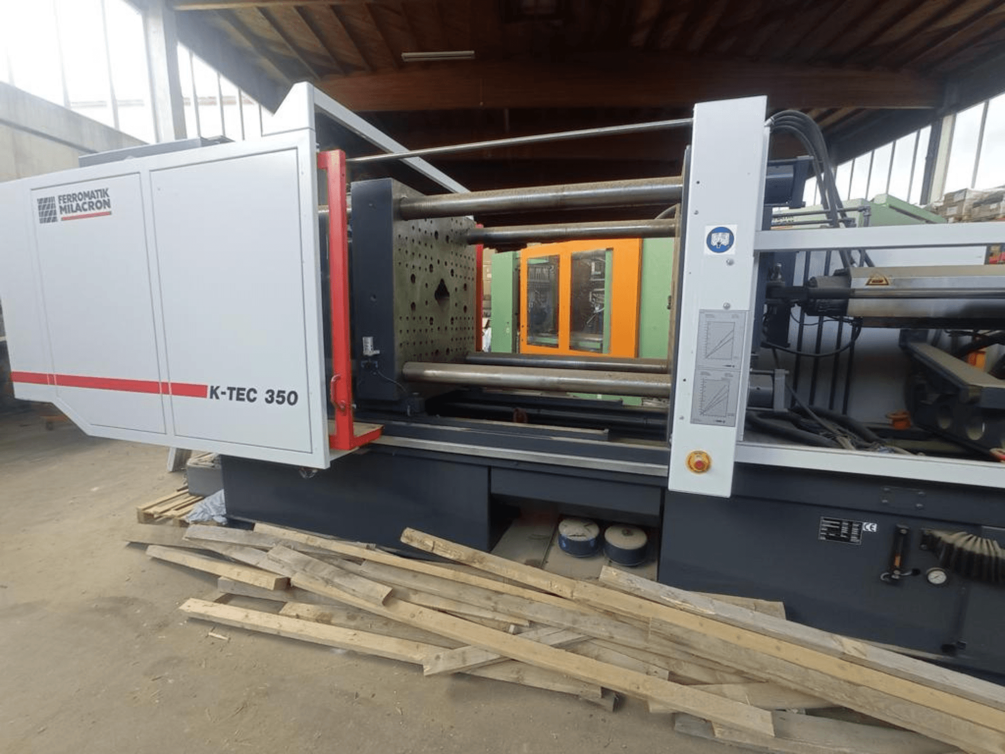 Šoninis vaizdas į pluošto lazerio pjovimo staklę „Prima Power Laser Genius+ 1530“, kuriame matomi išsamūs komponentai ir valdymo elementai.