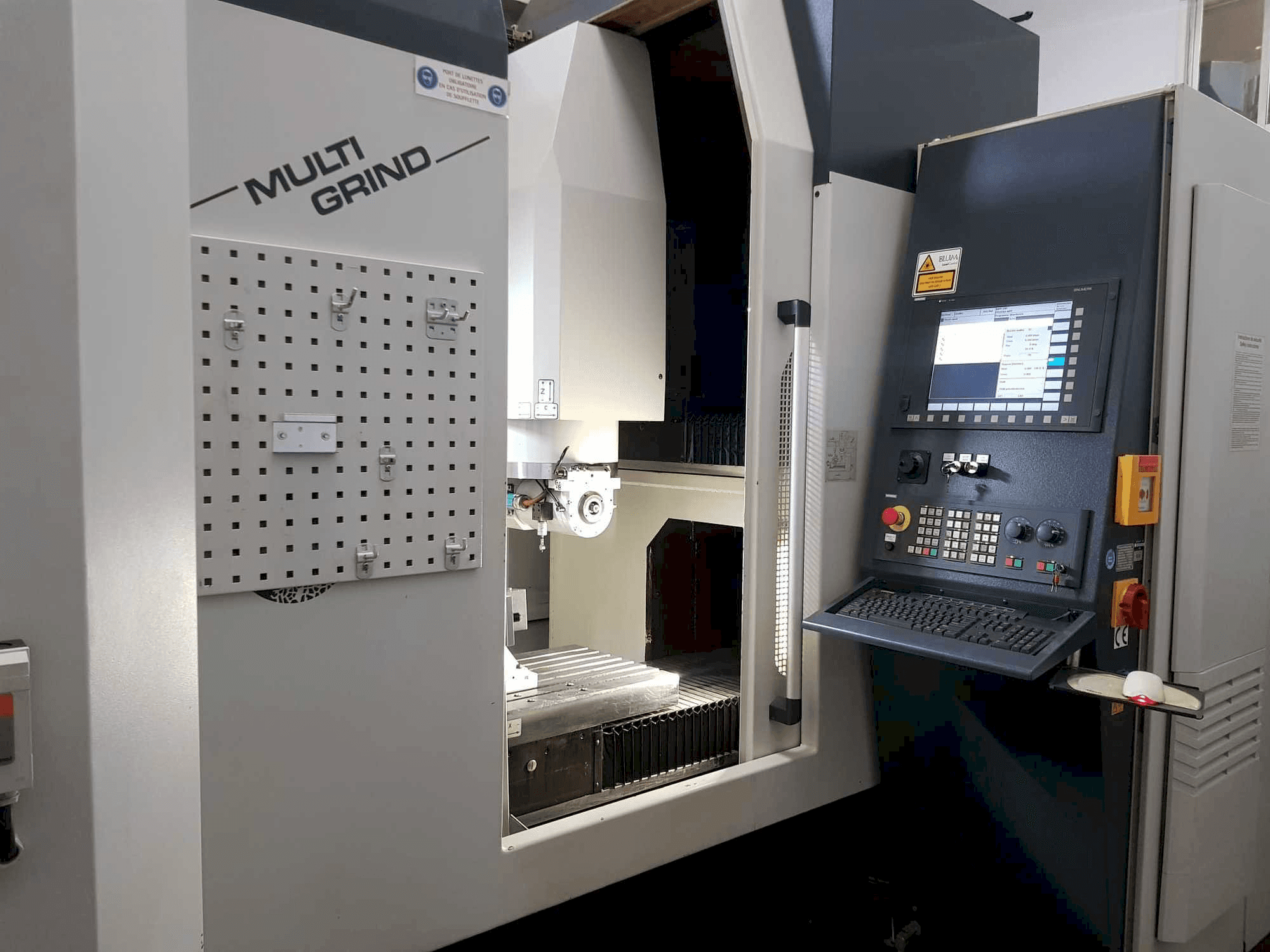 CNC staklės "Multi Grind" su valdymo skydeliu, laikymo lenta ir atvira darbo zona.